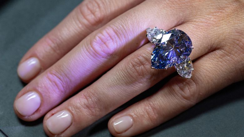 Christie's auction house intern Carola Chiadini holds the "Bleu Royal" diamond, weighing 17.61 carats, which is the largest to appear for sale in auction history, and that could sell for up to $50 million during an auction preview in Geneva, Switzerland, November 1, 2023.