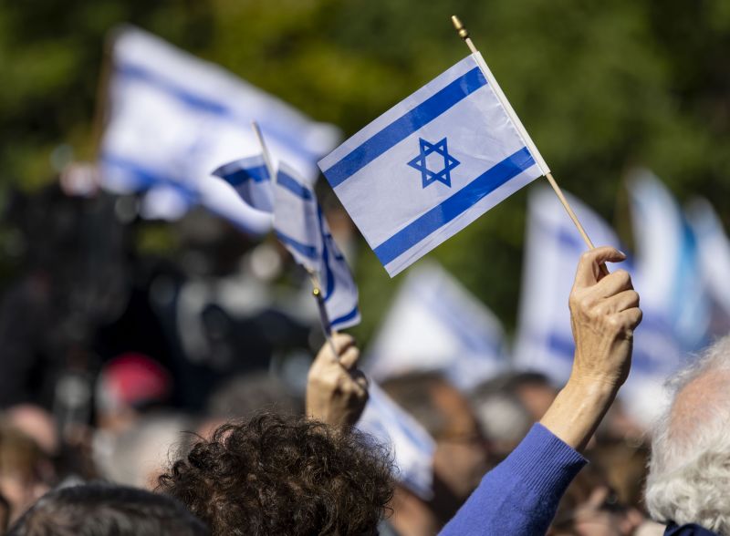 People wave flags during a community solidarity gathering for Israel hosted by the Jewish United Fund of Chicago on Tuesday, Oct. 10, 2023, outside North Shore Congregation Israel in Glencoe, Illinois. (Brian Cassella/Chicago Tribune/Tribune News Service via Getty Images)