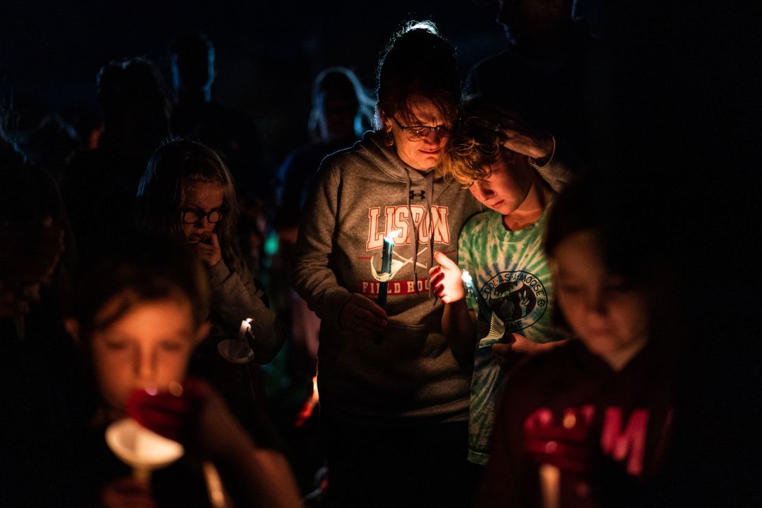 LISBON, ME - OCTOBER 28: Heidi Patrie embraces her son Conley Patrie, 12, as they join people from the the community gathered on a lawn during a vigil for the victims in Lisbon, Maine, Saturday, October 28, 2023. Robert Card, 40, the gunman opened fire killing at least 18 people in the neighbors city of Lewiston. The Patrie family were close friends with one of the victims. (Photo by Salwan Georges/The Washington Post via Getty Images)