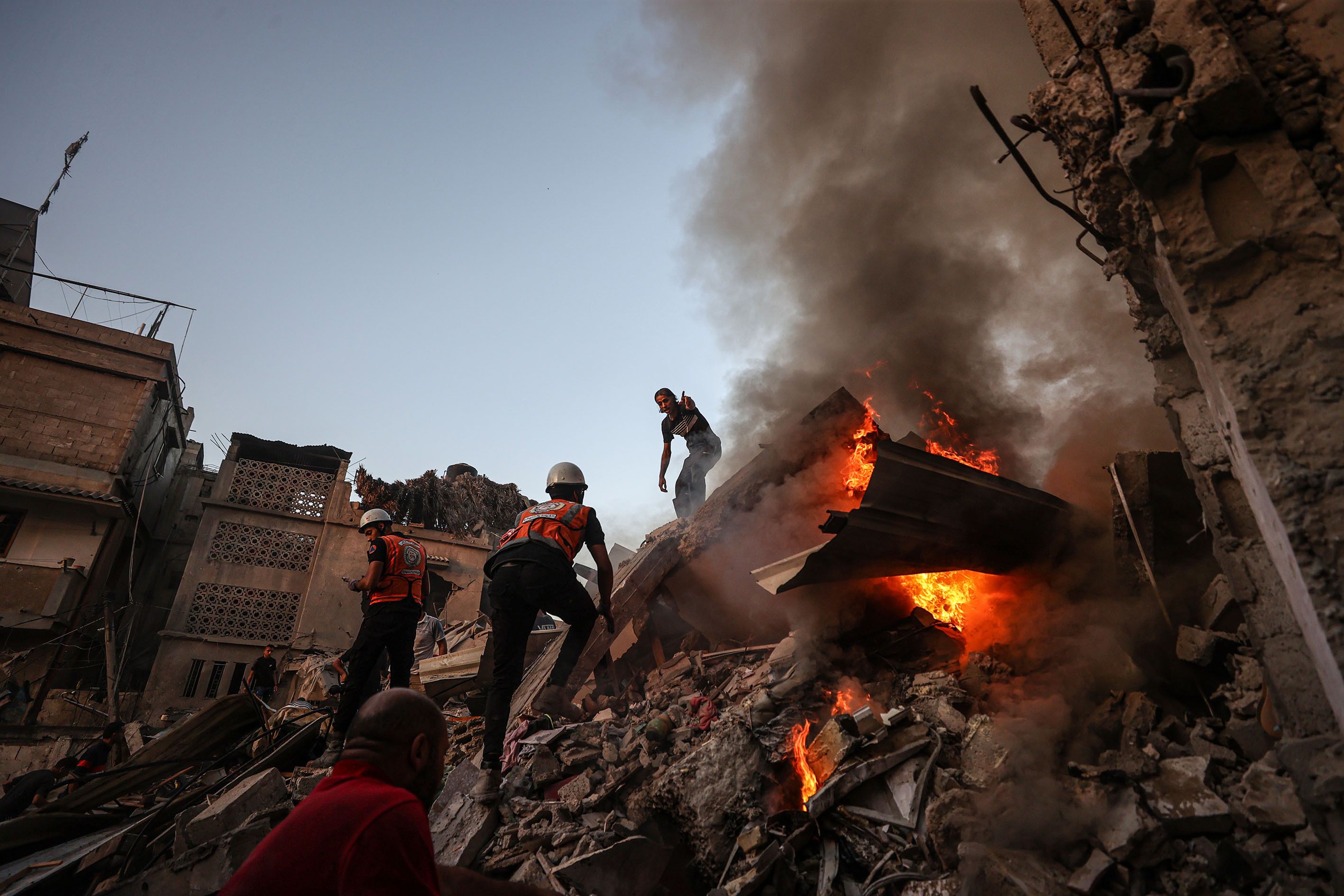 Teams put out a fire that broke out among the rubble of a destroyed building during search and rescue operations after an Israeli attack in Khan Younis, Gaza, on Saturday, November 4.