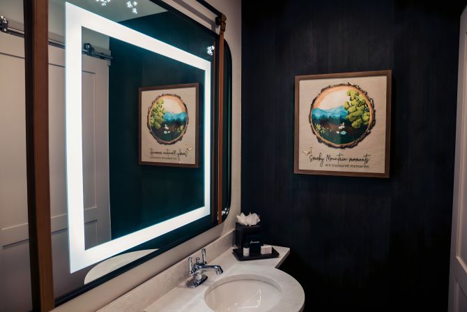 <strong>"Treasured memories": </strong>The bathrooms feature flattering, lighted mirrors with a firefly motif along the top and artwork nodding to Smoky Mountain moments.