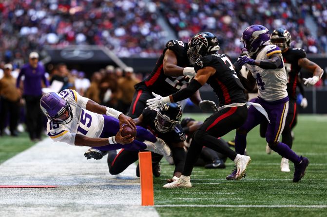 Minnesota Vikings backup quarterback <a href="https://www.cnn.com/2023/11/05/sport/vikings-josh-dobbs-spt/index.html" target="_blank">Joshua Dobbs</a> reaches for the pylon during the Vikings' 31-28 victory over the Atlanta Falcons on November 5. Dobbs, who was acquired by the Vikings in a trade last week, threw for 158 yards with two touchdowns in the air and one on the ground.