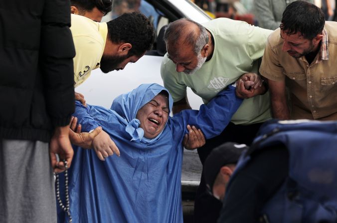 A family member reacts as Palestinian cameraman Mohammed Alaloul (bottom) covers the body of a relative killed in an Israeli strike, in Gaza on Sunday, November 5.