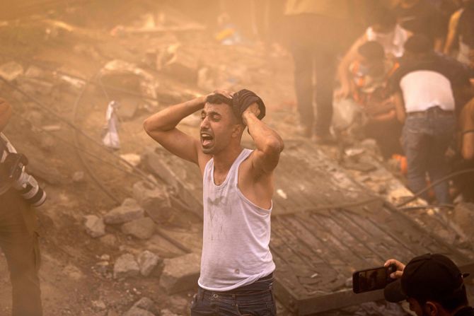 A Palestinian man reacts as others check the rubble of a building in Khan Younis, Gaza, on November 6.