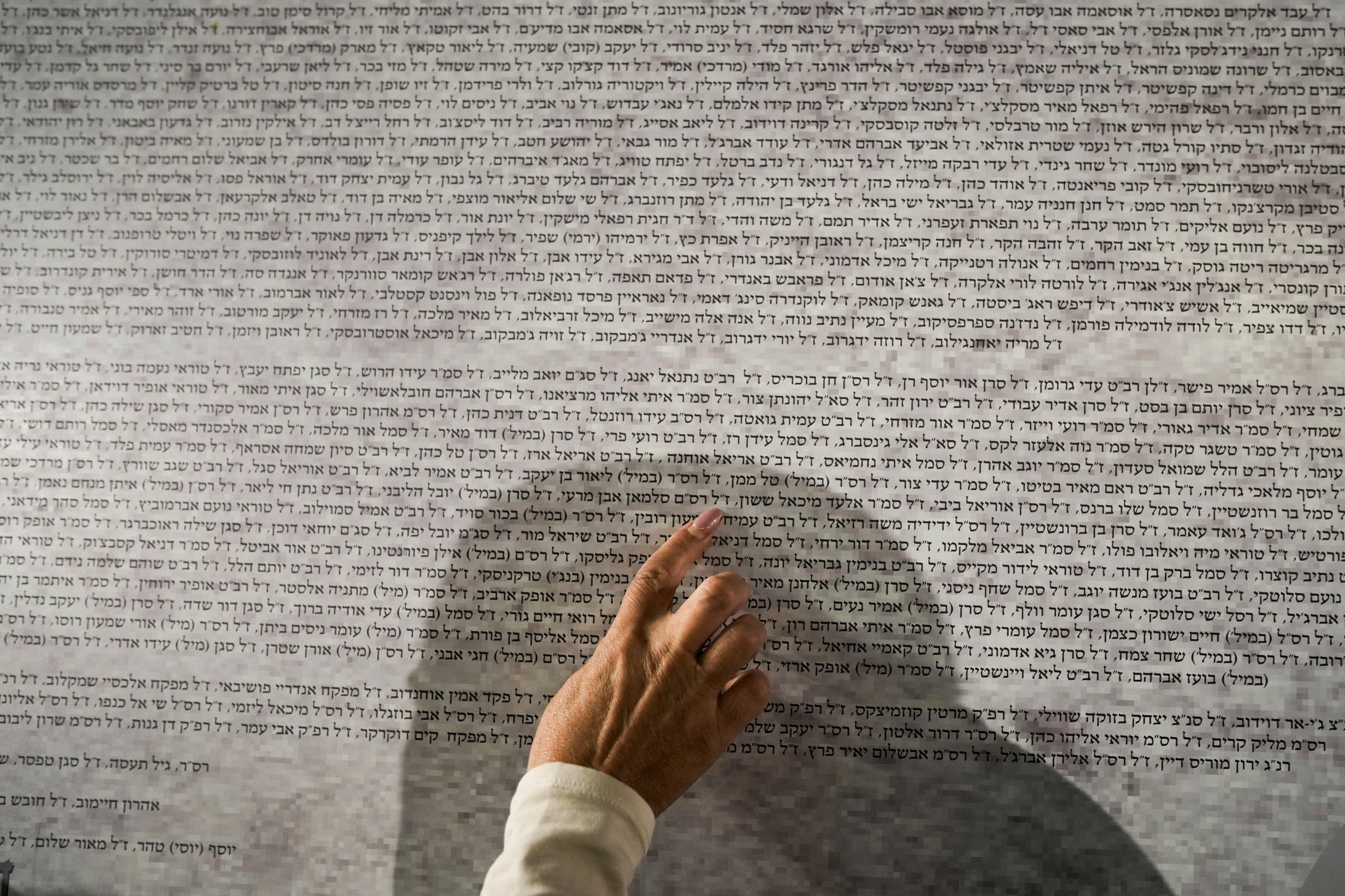 A woman looks for names on a memorial wall in Jerusalem's Old City on November 6 that lists the 1,400 people killed in the October 7 attack by Hamas militants on Israel.