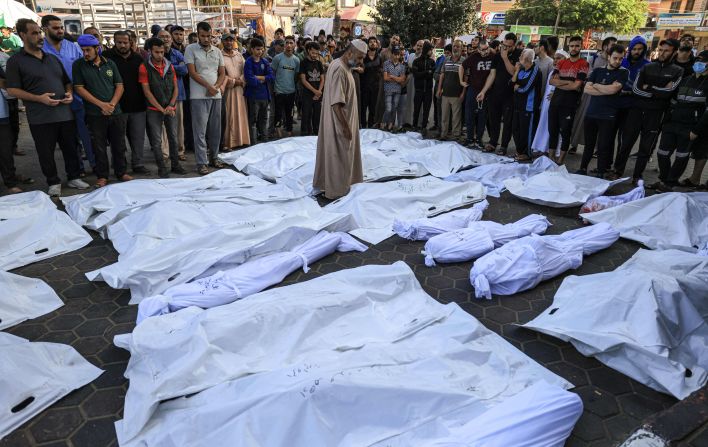 At the Shuhada Al-Aqsa hospital on November 6, a man walks between the shrouded bodies of people killed in the Israeli bombardment in Deir Balah, central Gaza.