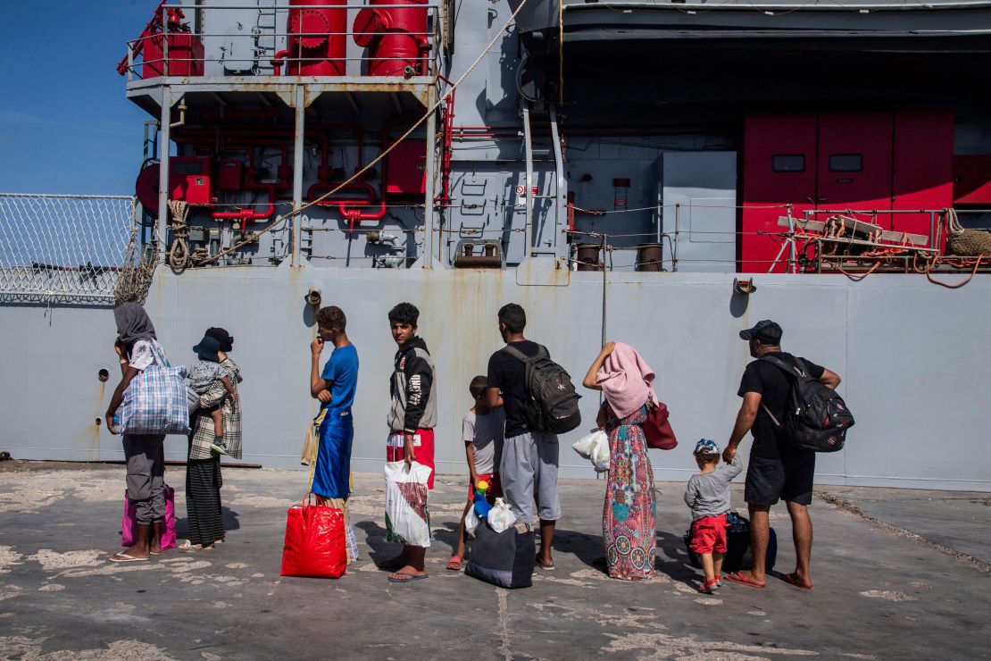 Migrants gather in the harbour of Italian island of Lampedusa, before being transferred to Porto Empedocle in Sicily region, south Italy, by the Italian military ship Cassiopea, on September 15, 2023. The island's reception centre, built to house fewer than 400 people, was overwhelmed with men, women and children forced to sleep outside on makeshift plastic cots, many wrapped in metallic emergency blankets. Good weather has seen a surge in arrivals across Italy in recent days, with more than 5,000 people landing across the country on September 12, and almost 3000 the day after, according to updated interior ministry figures. (Photo by Alessandro SERRANO / AFP) (Photo by ALESSANDRO SERRANO/AFP via Getty Images)