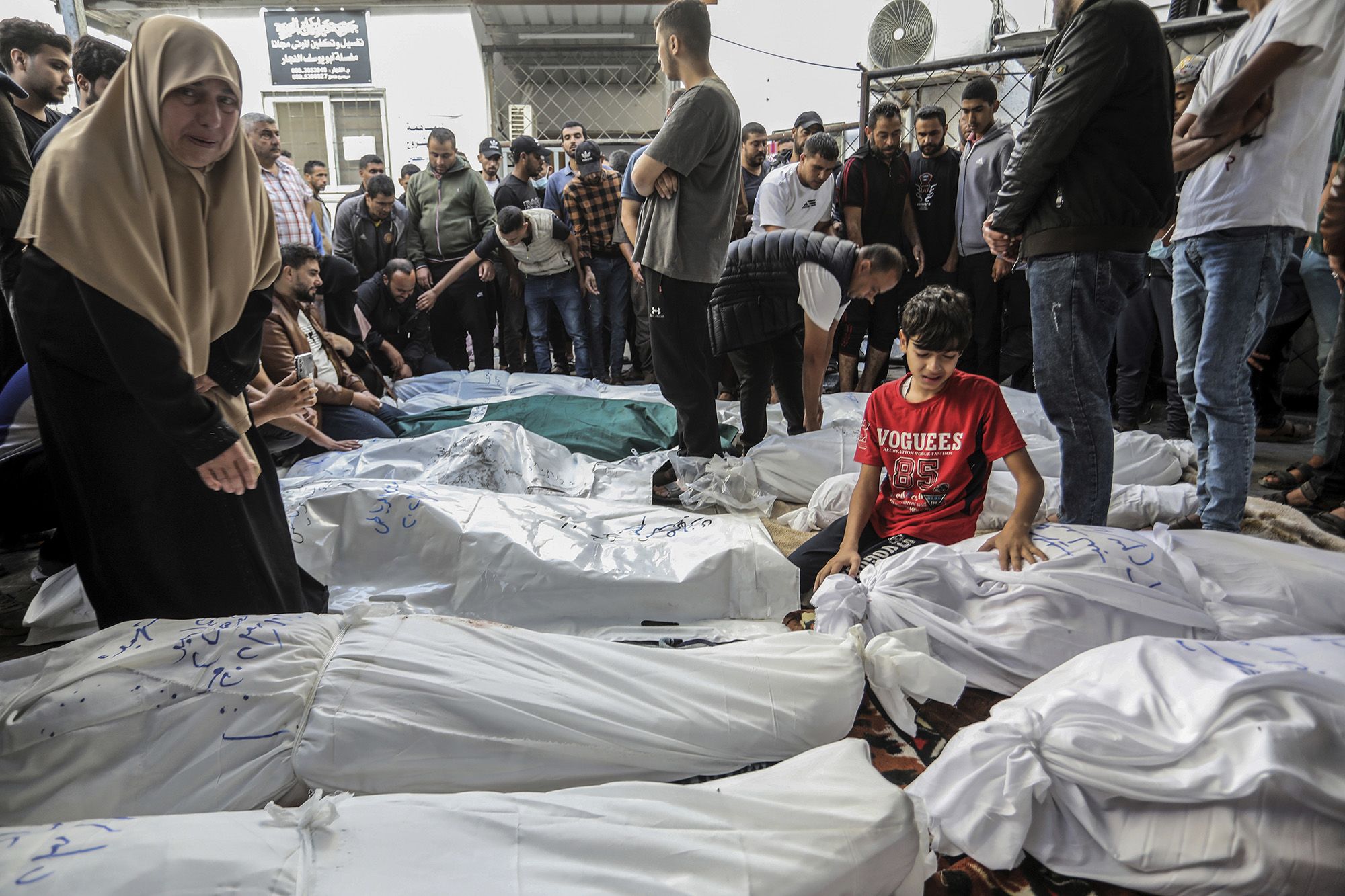 People mourn as they wait for the bodies of members of a family killed in a strike to be removed from Rafah's al-Najjar Hospital for burial on November 7.