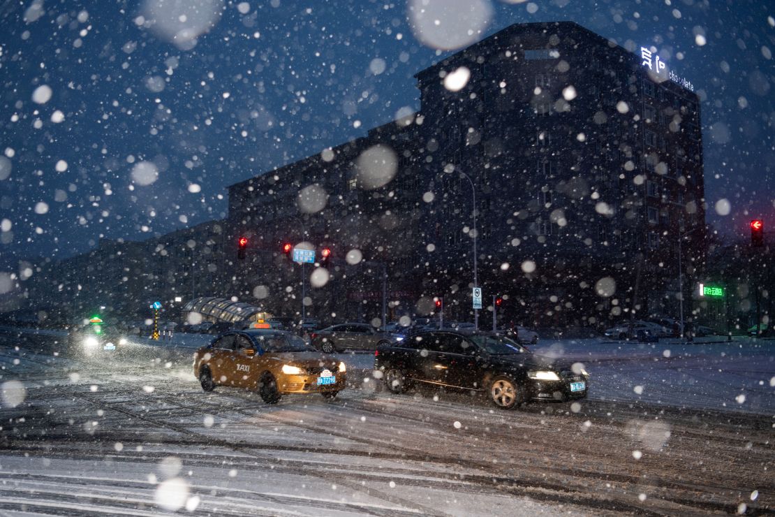 Vehicles drive in the snow in Xiangfang District of Harbin, capital city of northeast China's Heilongjiang Province, on Nov. 6, 2023.  Heilongjiang issued a red alert on Sunday for blizzards, according to the local meteorological service. Multiple cities in the province are expected to experience heavy snowfall, with accumulative precipitation ranging between 20 mm to 40 mm, from Sunday evening to Monday evening, according to the forecast. (Photo by Xie Jianfei/Xinhua via Getty Images)