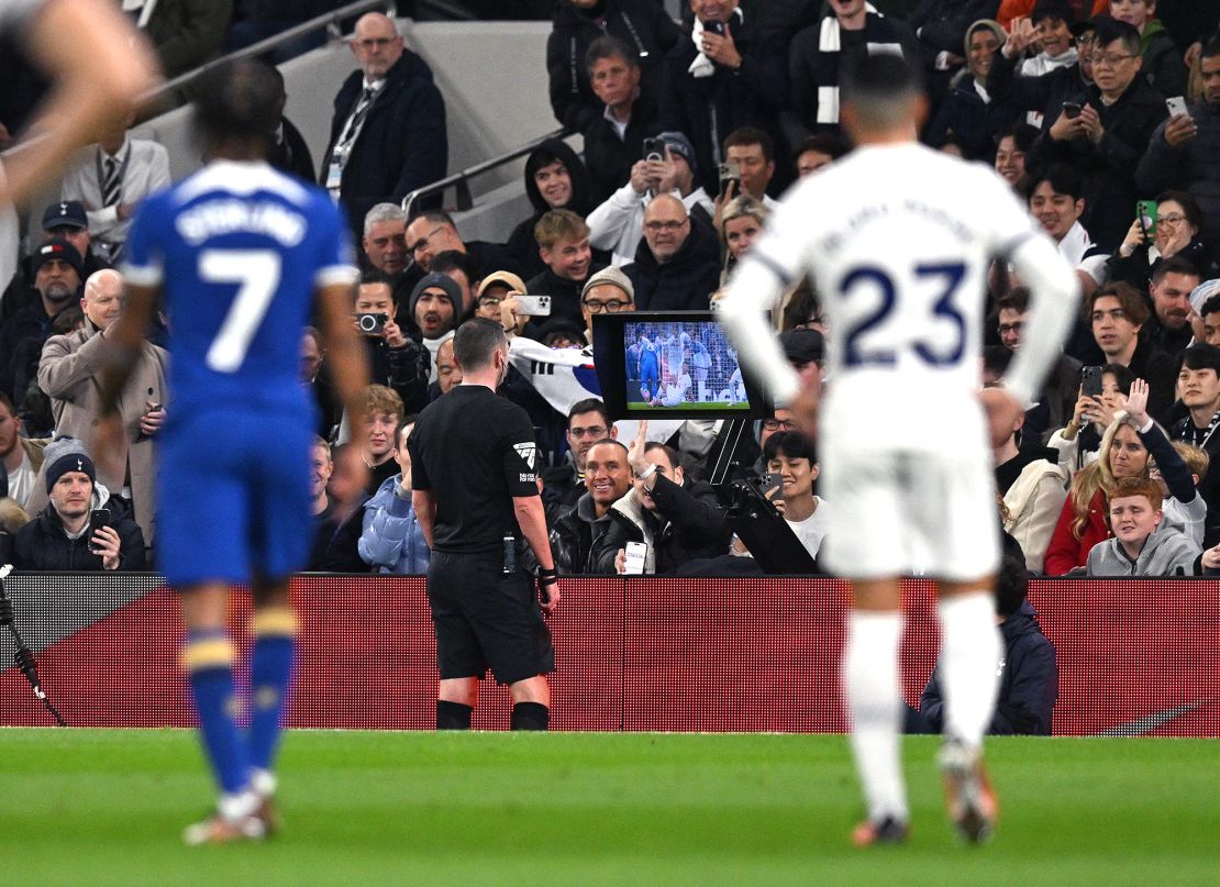 Referee Michael Oliver looks at a VAR replay of an incident  involving Tottenham Hotspur's Argentinian defender #17 Cristian Romero, during the English Premier League football match between Tottenham Hotspur and Chelsea at Tottenham Hotspur Stadium in London, on November 6, 2023. (Photo by Glyn KIRK / AFP) / RESTRICTED TO EDITORIAL USE. No use with unauthorized audio, video, data, fixture lists, club/league logos or 'live' services. Online in-match use limited to 120 images. An additional 40 images may be used in extra time. No video emulation. Social media in-match use limited to 120 images. An additional 40 images may be used in extra time. No use in betting publications, games or single club/league/player publications. /  (Photo by GLYN KIRK/AFP via Getty Images)