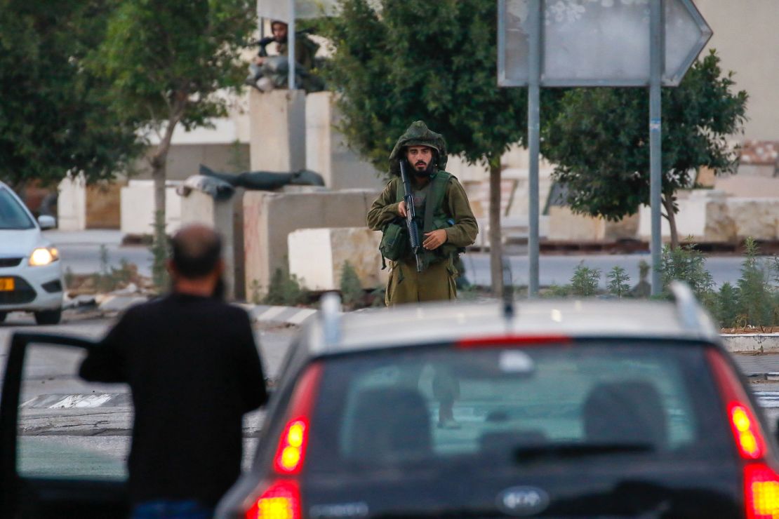 11/02/2023, Nablus, Palestine. Israeli soldiers have positioned themselves along the road between the West Bank cities of Nablus and Tulkarem. This move follows the tragic incident on November 2, 2023, near the Jewish settlement of Einav, where an Israeli citizen was killed when their car came under fire. The incident occurred amidst the ongoing conflict between Israel and the Palestinian group Hamas in the Gaza Strip. In response, the Israeli army has confirmed the establishment of roadblocks in the area and is actively pursuing the individuals believed to be responsible for the shooting near the Palestinian city of Tulkarm in the northern West Bank. (Photo by Wahaj Bani Moufleh / Middle East Images / Middle East Images via AFP) (Photo by WAHAJ BANI MOUFLEH/Middle East Images/AFP via Getty Images)