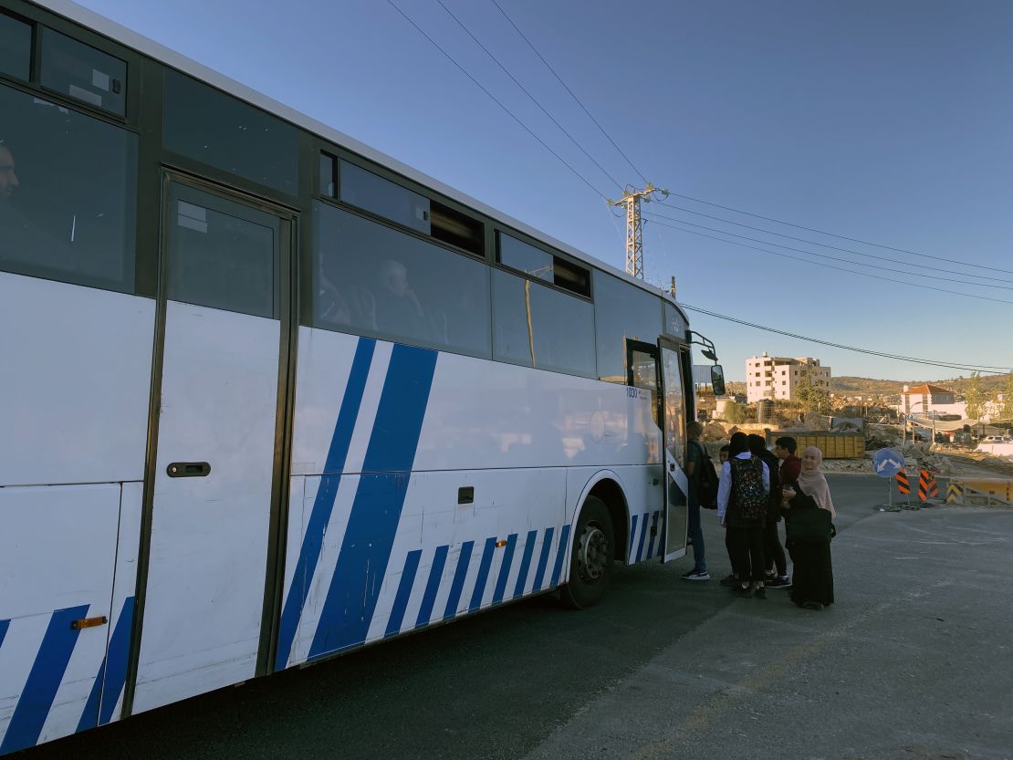 A bus taking West Bank residents trough an Israeli checkpoint and into Jerusalem stops to pick up passengers waiting by the side of the road.