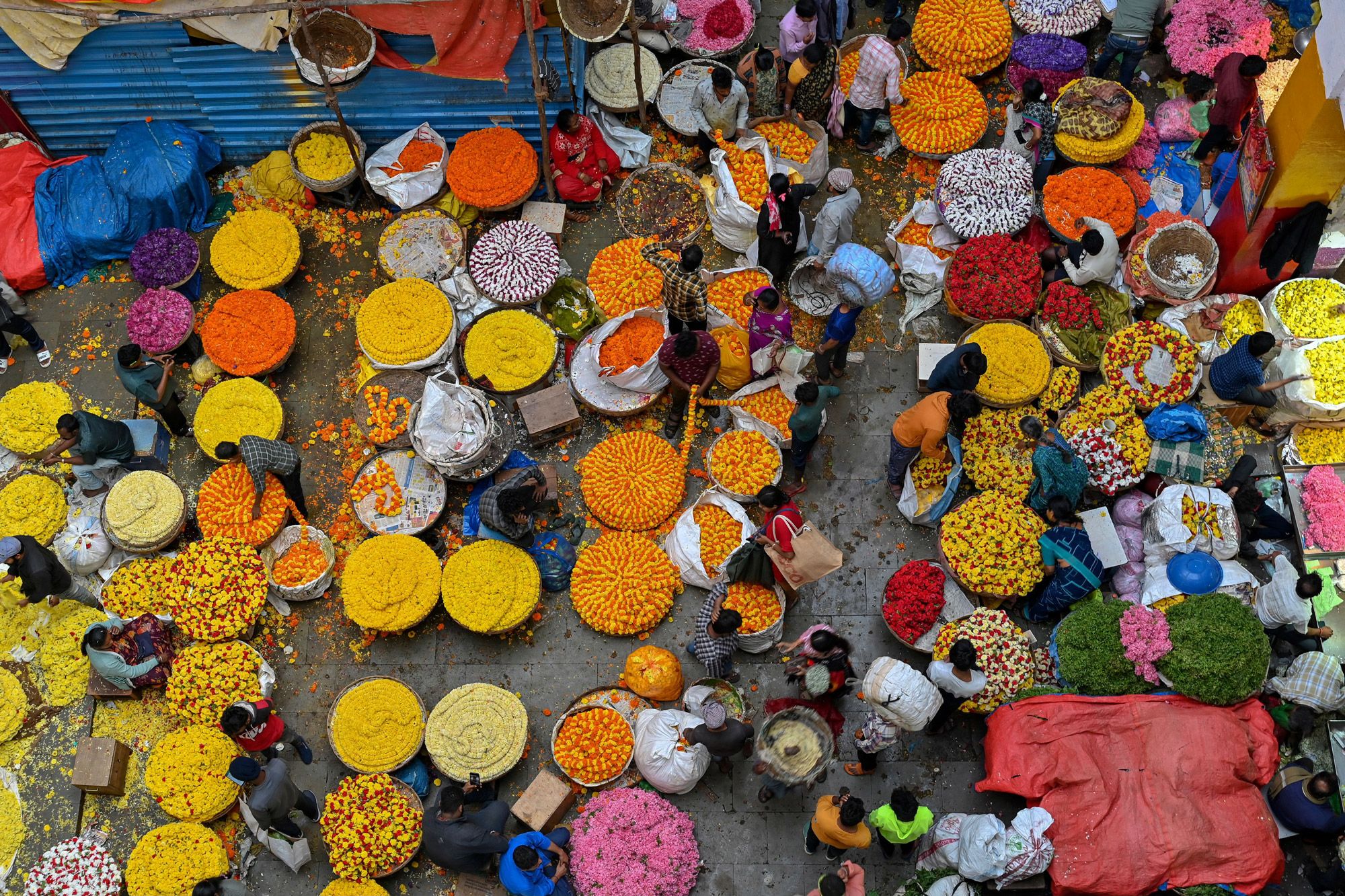 TOPSHOT - People crowd at a flower market on the eve of Diwali, the Hindu festival of lights, in Bangalore on October 23, 2022. (Photo by Manjunath KIRAN / AFP) (Photo by MANJUNATH KIRAN/AFP via Getty Images)