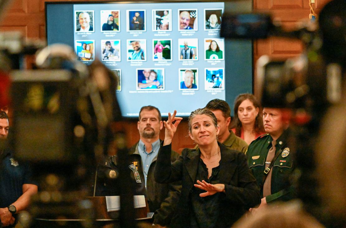 Deaf Interpreter Regan Thibodeau uses American Sign Language to address the media during a press conference at the Lewiston City Hall on Oct 27, 2023. Hundreds of law enforcement agents were scouring communities around Lewiston, Maine, for a person of interest in connection with two shootings at a bowling alley and bar that killed at least 16 people.