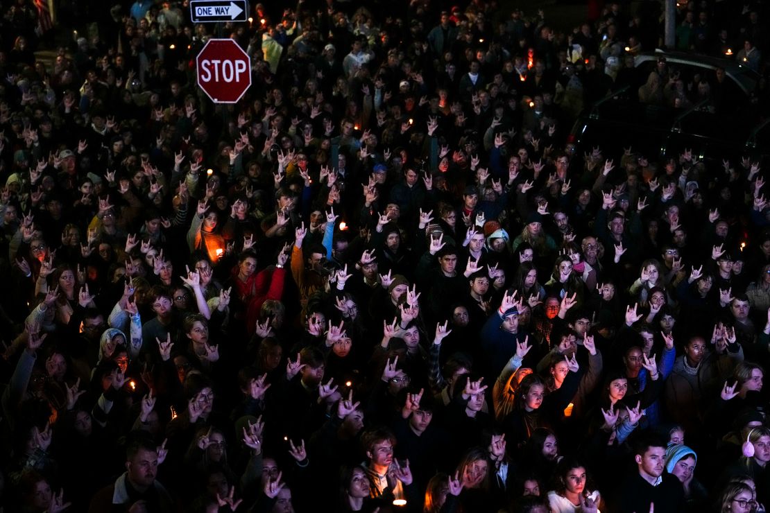People sign "I love you" while gathered at a vigil for the victims of Wednesday's mass shootings, Sunday, Oct. 29, 2023, outside the Basilica of Saints Peter and Paul in Lewiston, Maine. Several members of the deaf community were among the dead. (AP Photo/Matt Rourke)