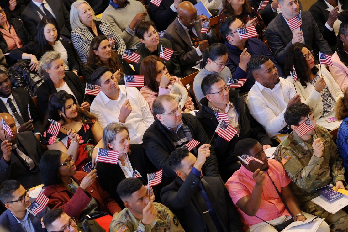 New U.S. citizens wave flags after taking the Oath of Allegiance during a Naturalization Ceremony at Faneuil Hall in Boston, Massachusetts, U.S., April 25, 2023.     REUTERS/Brian Snyder