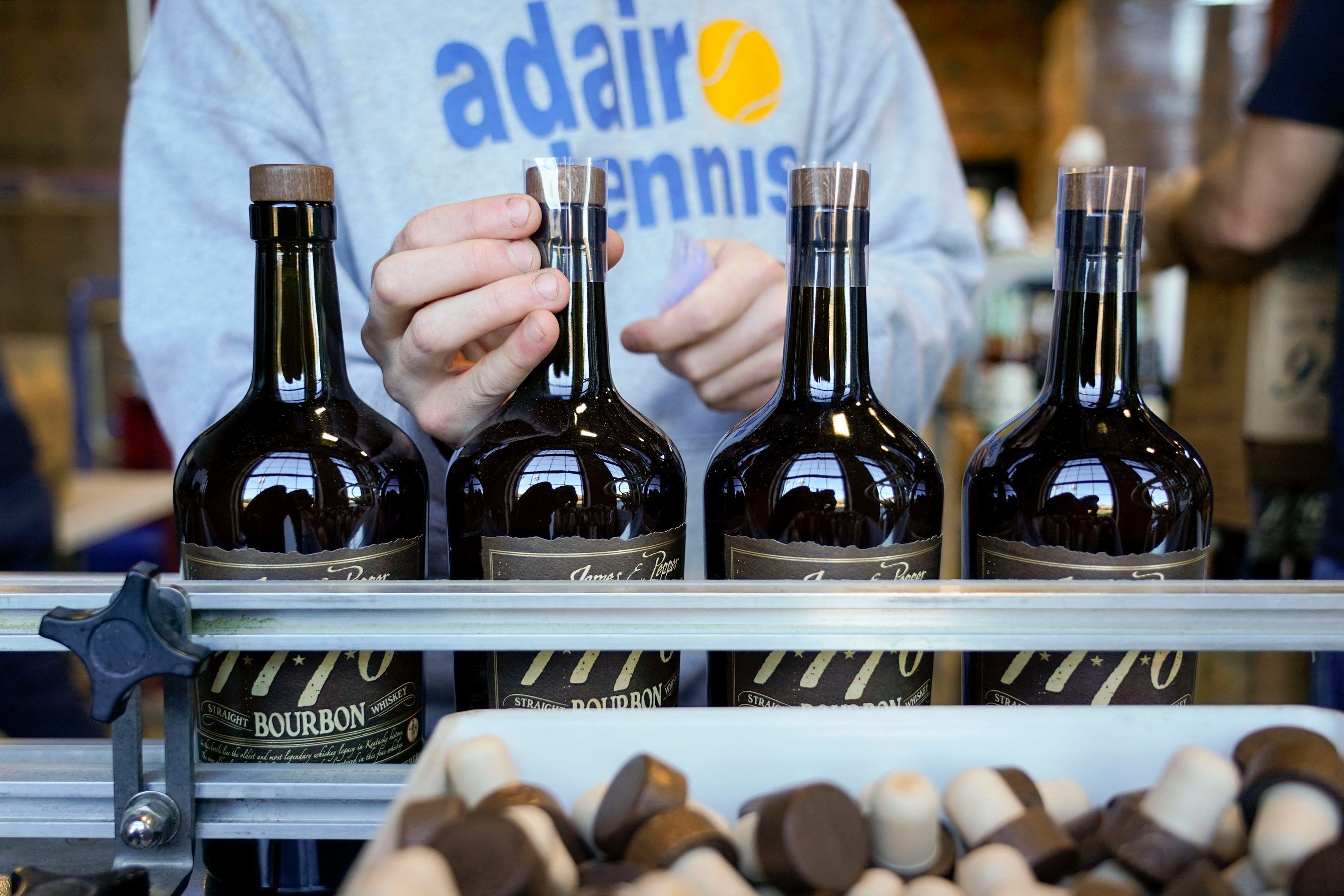 American whiskey companies could soon be subject to a 50% tariff on exports to the EU. Cody Giles seals American whiskey bottles on an assembly line at the James E. Pepper distillery in Lexington, Kentucky on December 14, 2021. (Photo by Jeff Dean / AFP) (Photo by JEFF DEAN/AFP via Getty Images)