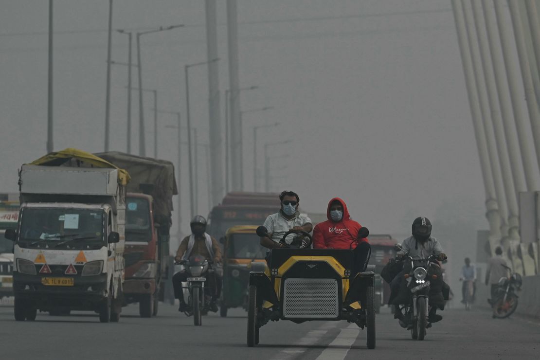 Commuters make their way along the Signature Bridge amid heavy smog conditions in New Delhi on November 9, 2023.