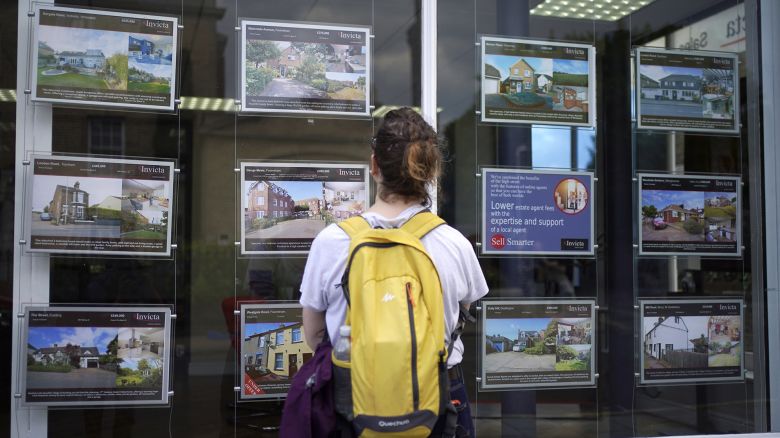 File photo dated 20/07/23 of a woman looking at advertisements in an estate agents window, as the average UK house price fell by 0.3% in July, marking the fourth monthly decline in a row, according to Halifax. 73262174 (Press Association via AP Images)