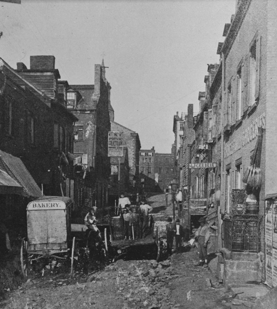 A baker's delivery wagon parked at the roadside, a sign on the other side of the road reads 'Lacerbier' in the Five Points neighborhood of Lower Manhattan in New York City, New York, circa 1885. The area was a notorious densely-populated slum. (Photo by Archive Photos/Getty Images)