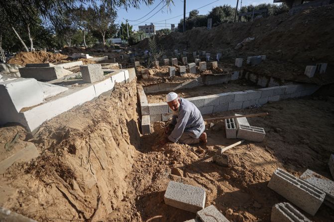 Cemetery attendant Sadi Berek, 63, works to maintain graves of children who were killed in the aftermath of Israeli attacks in Deir Al-Balah, Gaza, on Friday, November 10.