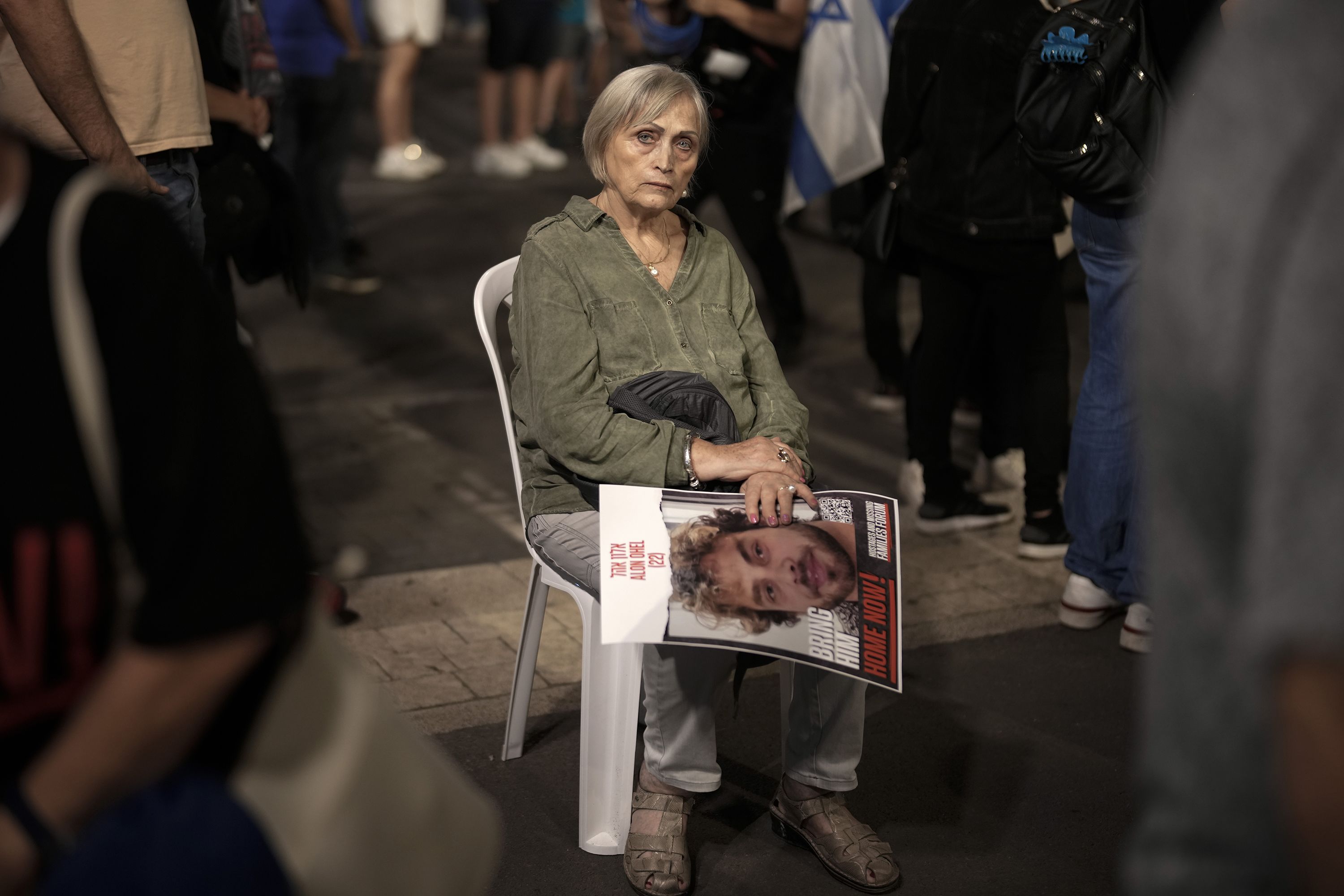 On day 35 of hostages being detained by Hamas, a woman holds the image of a hostage while sitting amongst thousands of people and families of kidnapped people taking part in a protest to demand that Israeli Prime Minister Benjamin Netanyahu secures the release of Israeli hostages, on November 11, in Tel Aviv, Israel. 