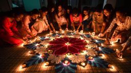 Students light earthen oil lamps on rangoli, a decorative design, on the occasion of the Diwali, a Hindu festival of lights in Guwahati on November 12, 2023. (Photo by Biju BORO / AFP) (Photo by BIJU BORO/AFP via Getty Images)