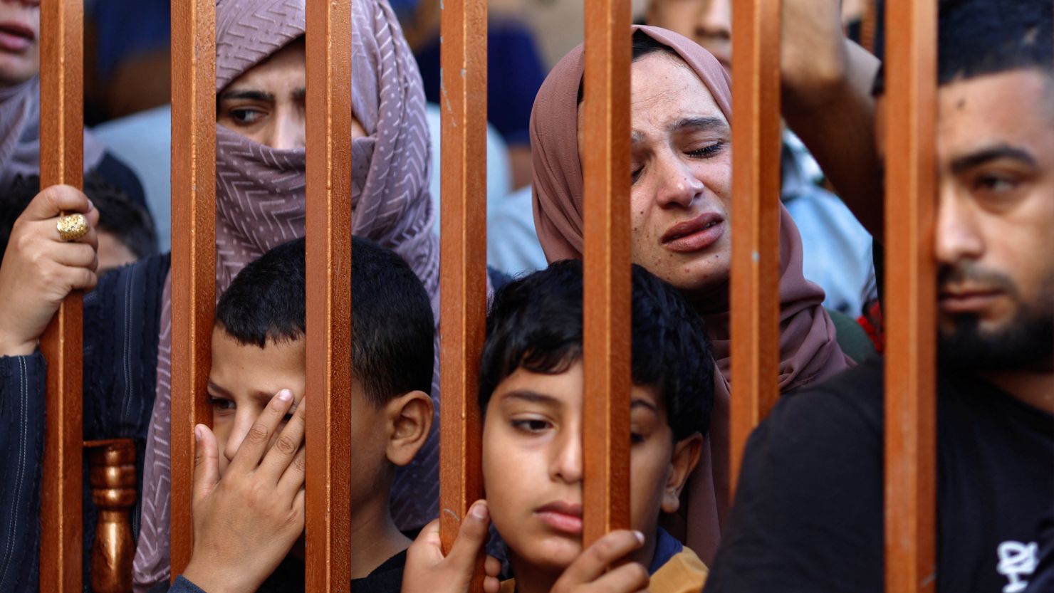 People react from behind a gate as the bodies of Palestinians killed by Israeli strikes are laid on the ground at a hospital, amid the ongoing conflict between Israel and Palestinian Islamist group Hamas, in Khan Younis in the southern Gaza Strip, November 3, 2023. REUTERS/Mohammed Salem