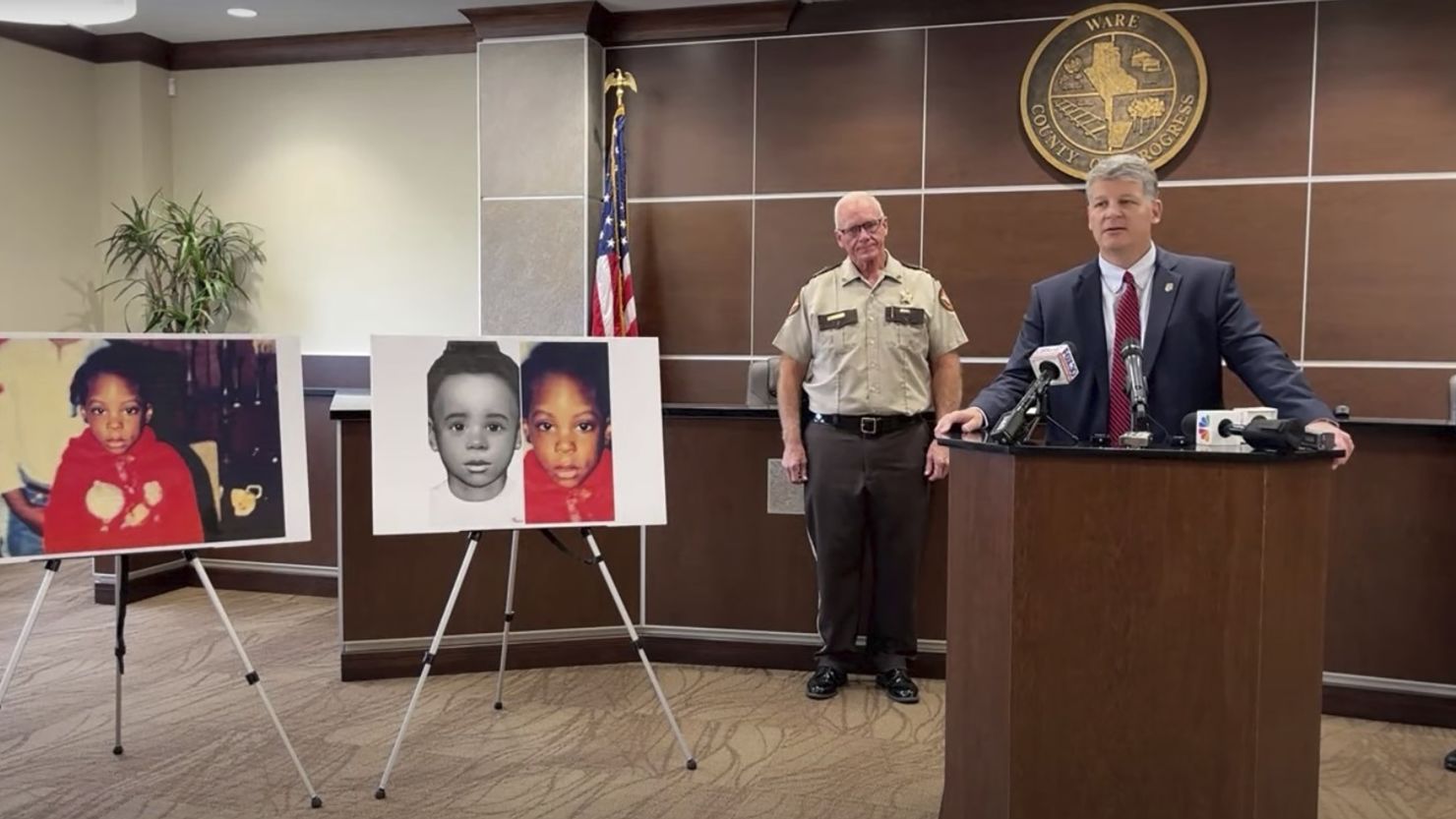 This screen grab taken from the Georgia Bureau of Investigation's livestream of the news conference shows Georgia Bureau of Investigation Agent Jason Seacrist, at podium, and Ware County Sheriff Carl James addressing reporters in Waycross, Ga., Monday, Nov. 13, 2023, to announce a break in an unsolved child death that stumped investigators for nearly 35 years. Authorities said they have identified a girl whose body was found encased in concrete in December 1988 as 5-year-old Kenyatta Odom. The girl's mother and a then-boyfriend have been charged with the child's murder and other crimes.
