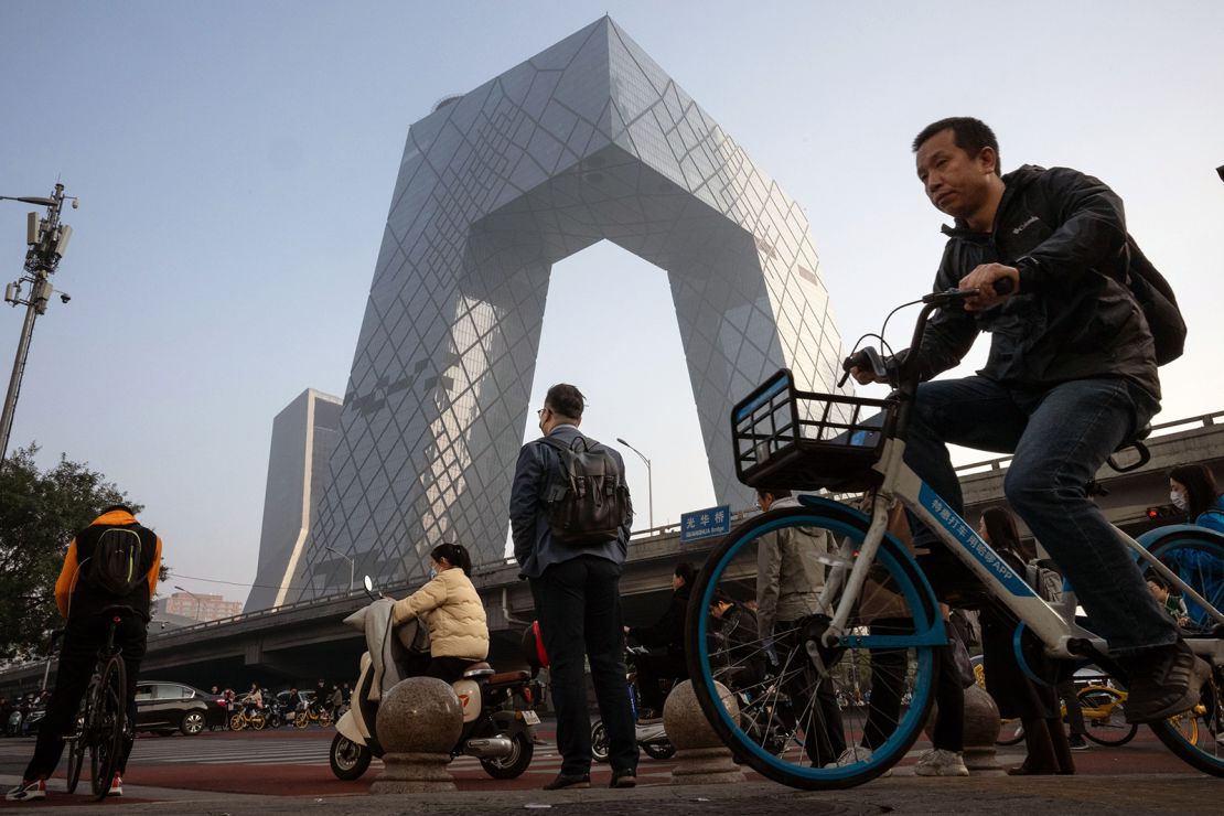 Morning commuters pass the CCTV tower in Beijing, China, on Monday, Oct. 30, 2023. China's stock turnover rose above 1 trillion yuan ($136 billion) Oct. 30 for the first time in about two months, in a sign that trading appetite is returning after policymakers took more steps to boost demand.