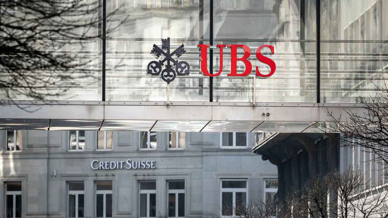 A sign  and logo of Credit Suisse bank is seen beneath a sign of Swiss giant banking UBS in Zurich on March 20, 2023. - Shares in European banks sank on March 20, 2022 despite a buyout of Credit Suisse by Swiss lender UBS aimed at preventing a global banking crisis. (Photo by Fabrice COFFRINI / AFP) (Photo by FABRICE COFFRINI/AFP via Getty Images)