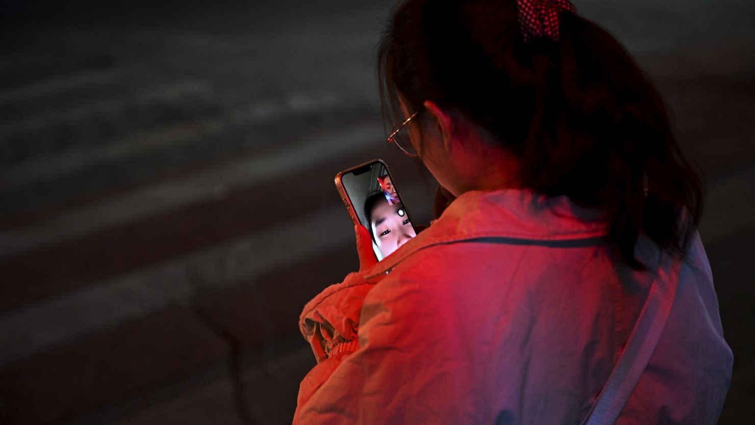 BEIJING, CHINA - NOVEMBER 15: A woman makes a video call with a friend as she waits at an intersection to cross during rush hour on November 15, 2023 in Beijing, China. Chinas President Xi Jinping is expected to meet U.S. President Joe Biden Wednesday during his visit to San Francisco for the APEC summit, where Chinas economy is expected to top the agenda for the leader of the worlds second largest economy. (Photo by Kevin Frayer/Getty Images)