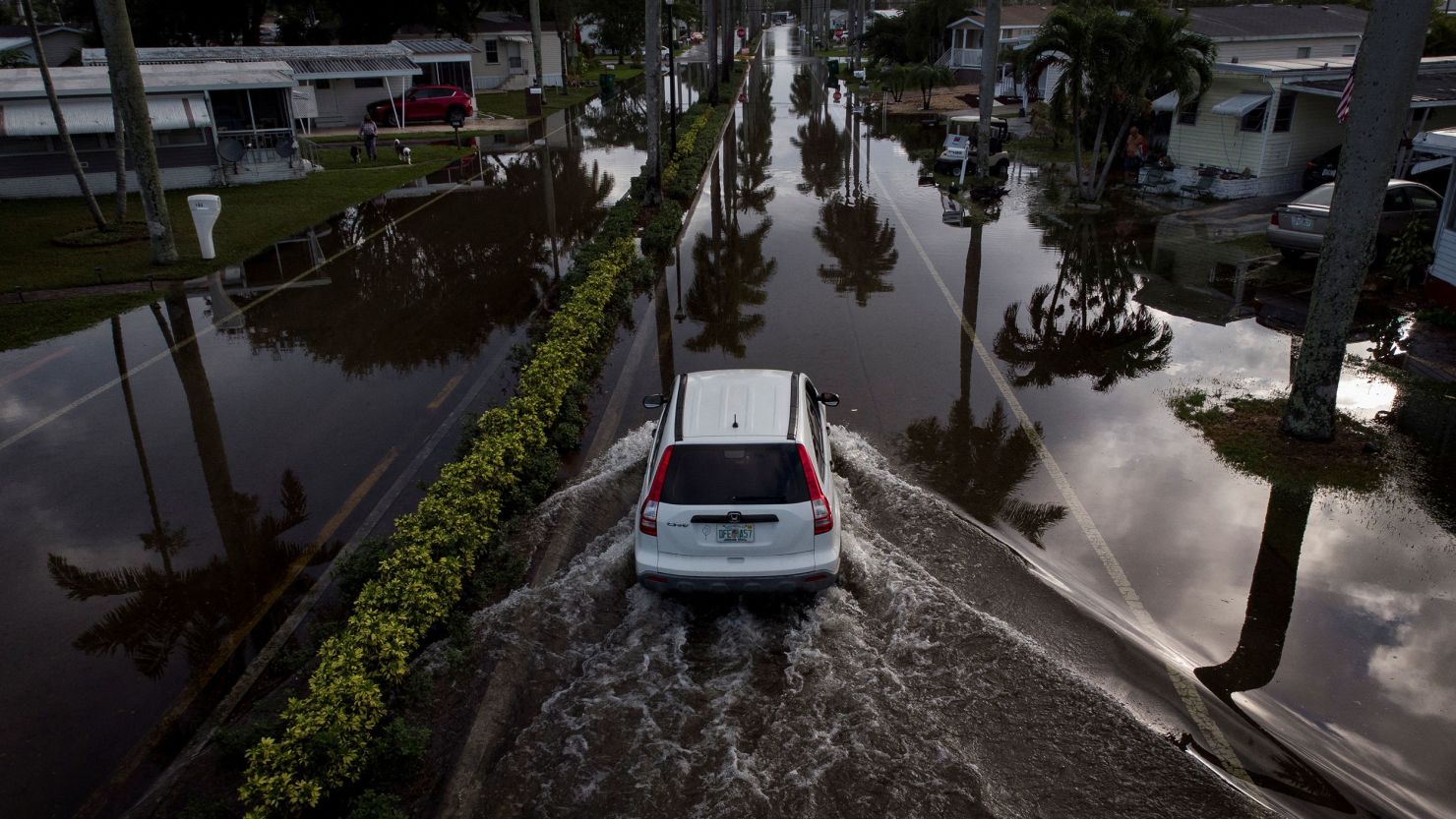 A car drives through flood water, in a trailer park community in Davie, Florida, U.S., November 16, 2023. REUTERS/Marco Bello
