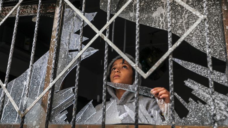 A Palestinian child looks through a broken window of a destroyed building, in Rafah, Gaza on November 15.