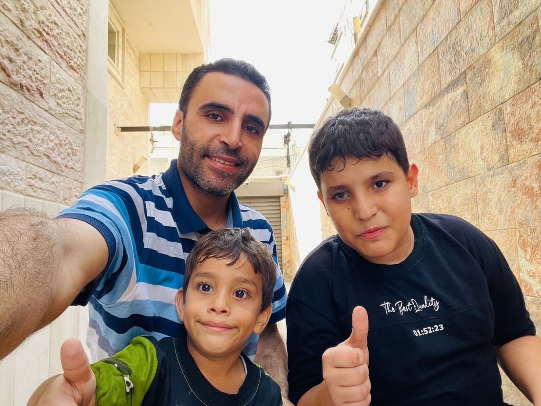 Hazem stands with Hamza (age 3) and Muhammad (age 12) who suffers from autism and a problem in his right eye (November 9- at the new shelter)- sent by Hazem Al-Naizi.jpeg