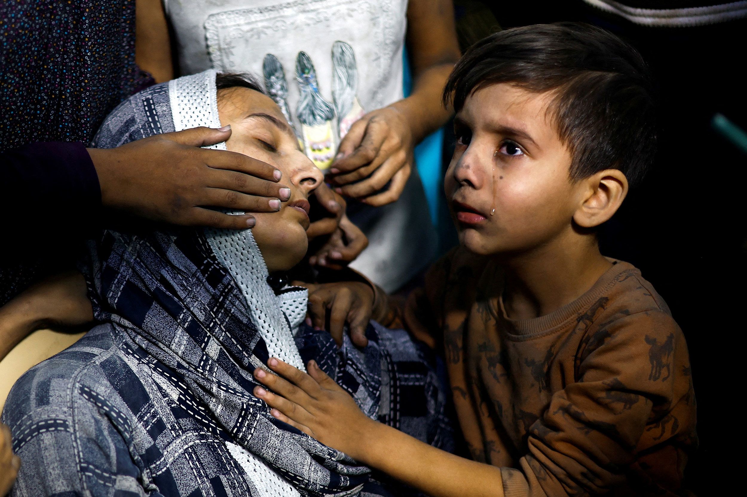 A Palestinian child cries next to his mother after they were rushed to the Nasser Hospital following an Israeli strike in Khan Younis, Gaza, on Monday, November 13.