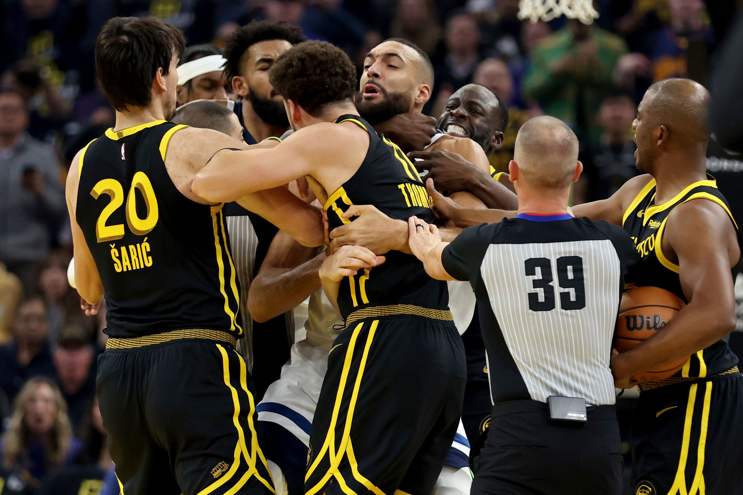 The Golden State Warriors' Draymond Green, back right, puts Minnesota Timberwolves center Rudy Gobert in a headlock during an NBA game in San Francisco on Tuesday, November 14.