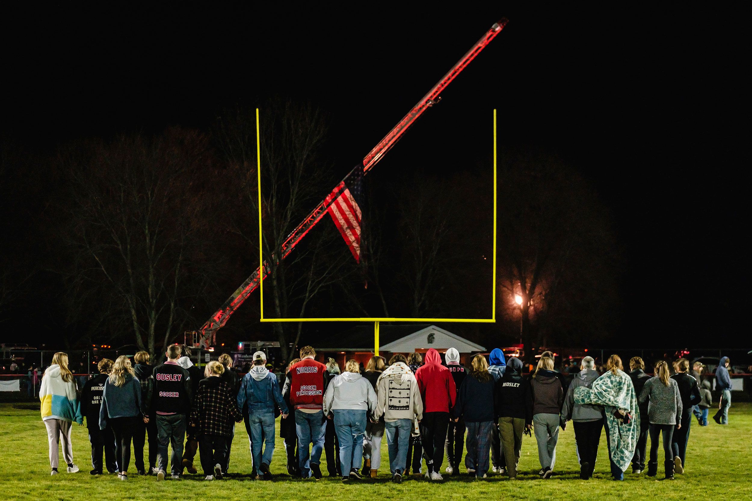 Students walk on a football field to attend a prayer vigil in Zoarville, Ohio, on Tuesday, November 14.