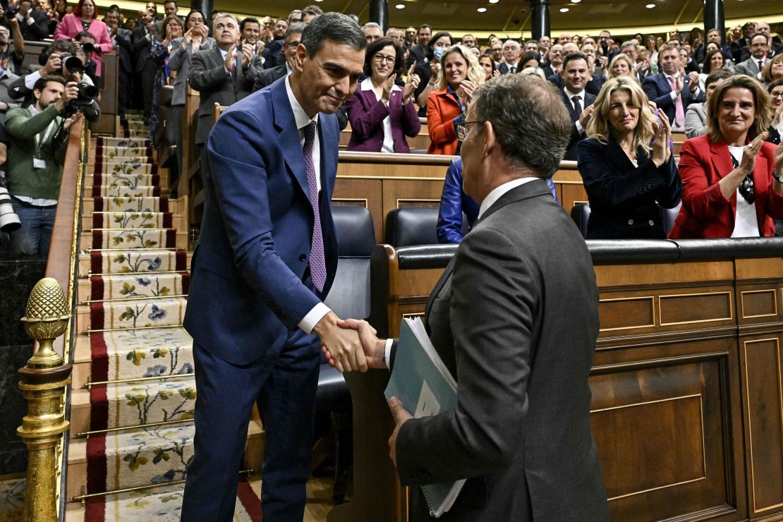 Spain's acting Prime Minister Pedro Sanchez (L) is congratulated by Partido Popular (PP) leader Alberto Nunez Feijoo after winning a parliamentary vote to elect Spain's next premier, at the Congress of Deputies in Madrid on November 16, 2023.