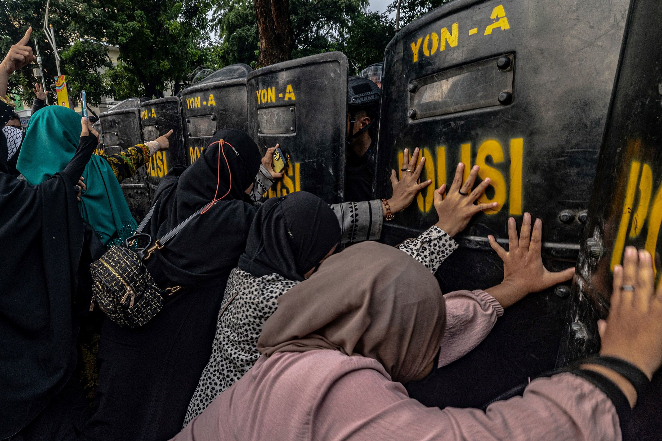 Protesters push against the shields of anti-riot police officers as they demand the cancellation of a Coldplay concert in Jakarta, Indonesia, on Wednesday, November 15.