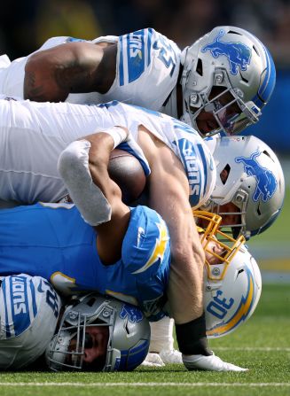 Los Angeles Chargers running back Austin Ekeler, second from bottom, is tackled by Detroit's Aidan Hutchinson and Derrick Barnes, top, during the Chargers' 41-38 loss to the Lions on November 12. Detroit linebacker Jack Campbell is on the bottom.