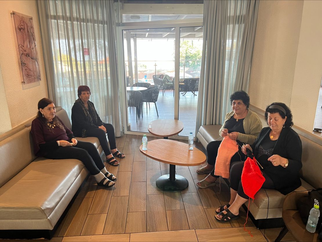 A group of cousins, who were evacuated from the town of Dovev, knit quietly in a hotel lobby in Tiberias, Israel on November 16.
