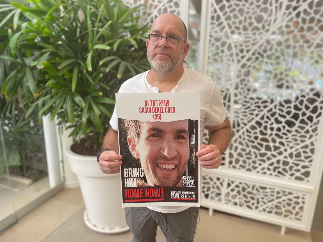 Jonathan Dekel-Chen holding photo/poster of his missing son, Sagui Dekel-Chen.