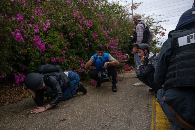 Foreign journalists get off a bus and take cover on the side of a road in Mavki'im, Israel, after a siren warns of a rocket fired from Gaza on November 19.
