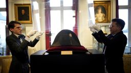 Raphael Pitchal, left, and Jean Christophe Chataignier of Osenat's auction house remove the protection of one of the signature broad, black hats that Napoléon wore when he ruled 19th century France and waged war in Europe at Osenat's auction house in Fontainebleau, south of Paris, Friday, Nov. 17, 2023. The hat is tipped to fetch more than half a million euros (dollars) at the auction Sunday of Napoleonic memorabilia patiently collected by a French industrialist. (AP Photo/Christophe Ena)