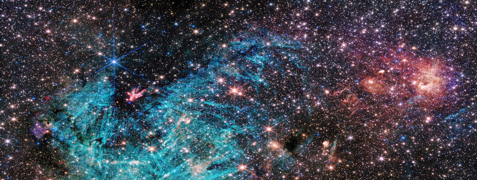 There are approximately 500,000 stars in this image of the Sagittarius C region of the Milky Way. The bright cyan area contains emissions from ionized hydrogen.