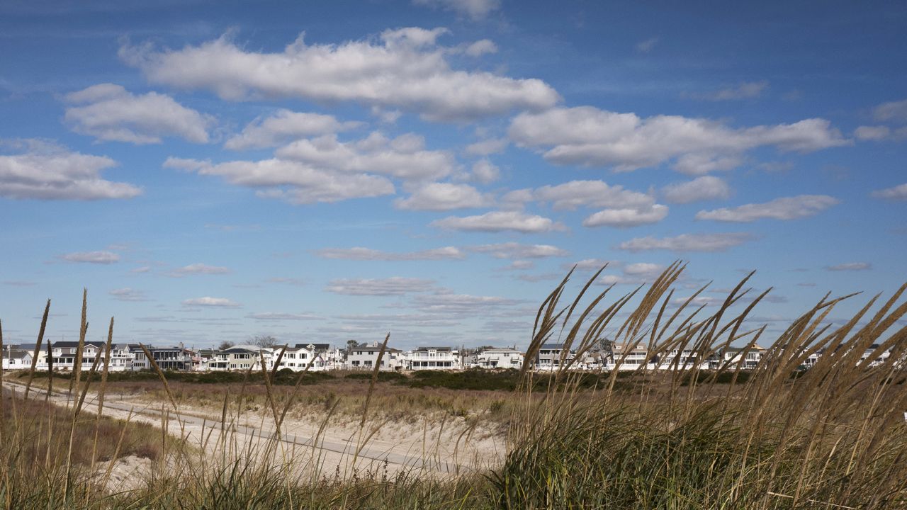 In this Oct. 26, 2016 photo, beach grass is now growing on top of a dune constructed to protect the homes in the Breezy Point neighborhood in the Queens borough of New York. People have worked hard, and mostly successfully, over the past four years to restore the New York and New Jersey coastline to what it was before Superstorm Sandy crashed ashore. But some areas have not recovered, nor will they ever from the Oct. 29, 2012, storm.  (AP Photo/Mark Lennihan)