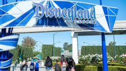 Visitors enter Disneyland on the day of the park's re-opening on April 30, 2021, in Anaheim, California. (Photo by VALERIE MACON / AFP) (Photo by VALERIE MACON/AFP via Getty Images)
