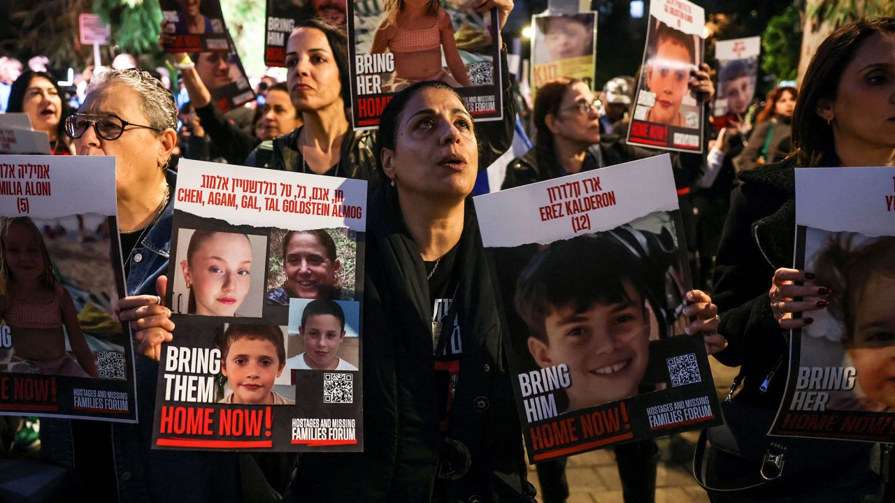 A woman holds portraits of hostages Erez Kalderon, 12, and of children of the Goldstein Almog family as protesters rally outside the Unicef offices in Tel Aviv on November 20, 2023 to demand the release of Israelis held hostage in Gaza since the October 7 attack by Hamas militants, amid ongoing battles between Israel and the Palestinian armed group. (Photo by AHMAD GHARABLI / AFP) (Photo by AHMAD GHARABLI/AFP via Getty Images)