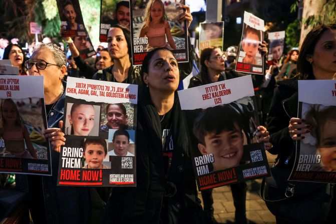 People hold portraits of children held hostage by Hamas as protesters rally outside the Unicef offices in Tel Aviv, Israel, on November 20.
